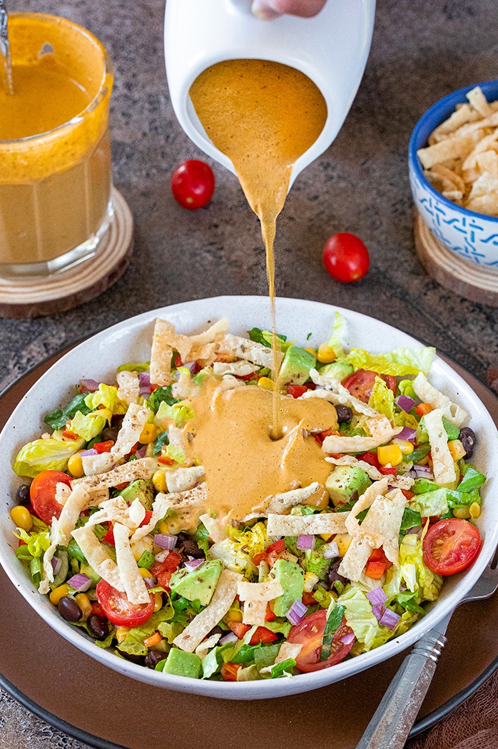 Pour chipotle dressing on salad