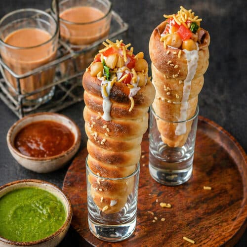 Crispy Chatpati Cone Chaat filled with potatoes, chickpeas, yogurt, chutneys, onions, tomatoes, and sev