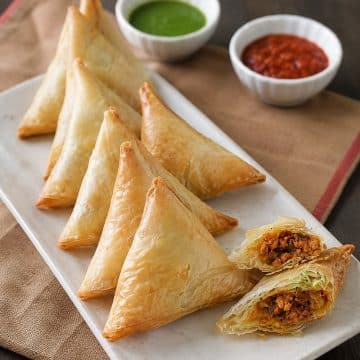Close-up of flaky Keema Samosa showing savory minced meat filling inside.