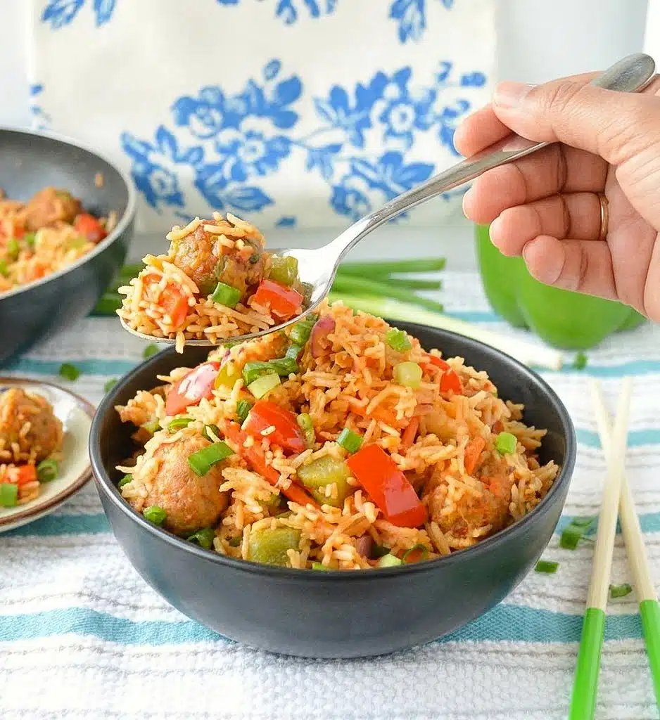 Veg Manchurian fried rice served in a bowl with colorful vegetables and homemade Manchurian balls on top