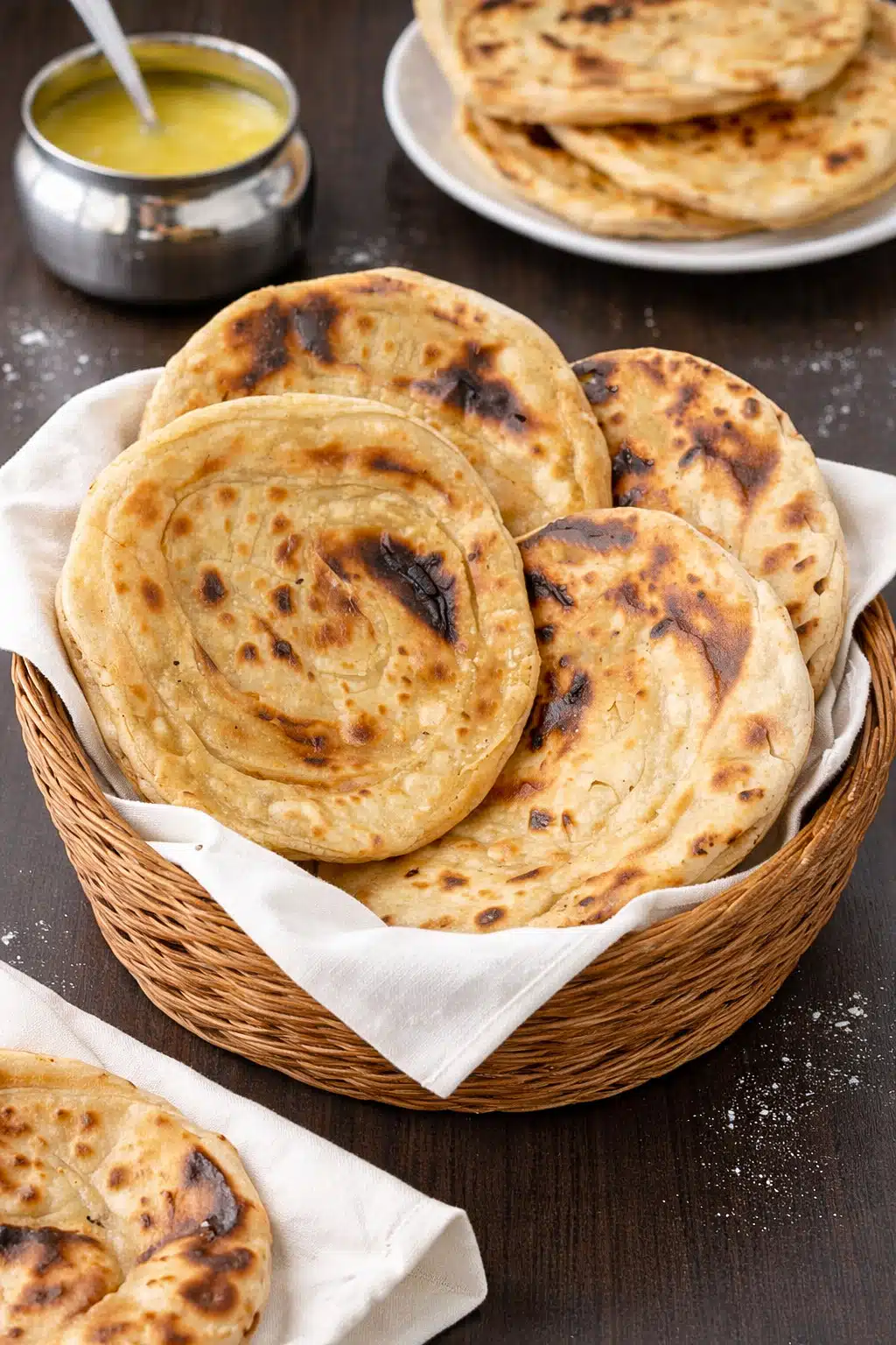 Rustic Indian tandoori roti without oven in a basket with melted ghee