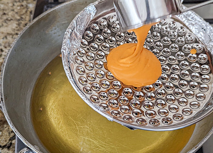 Pour batter in boondi jhara