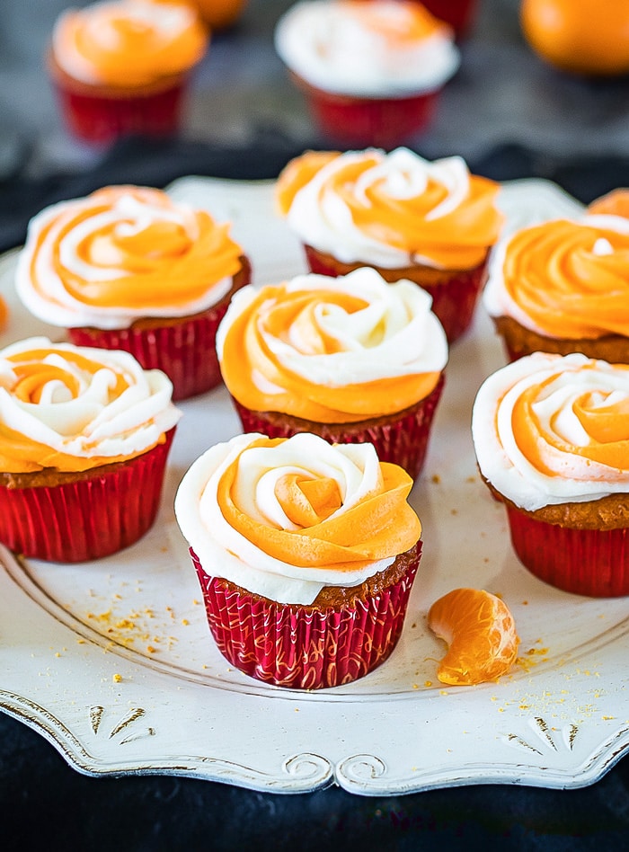 Frosted eggless orange cupcakes on a tray