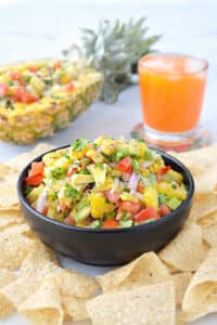 Colorful pineapple salsa with avocado and tomatoes in a serving bowl