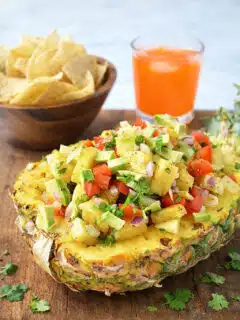 Pineapple salsa appetizer served with tortilla chips and fresh herbs
