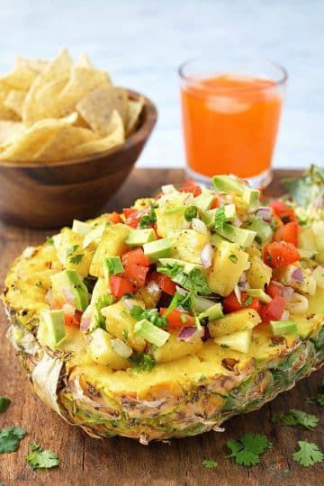 Pineapple salsa appetizer served with tortilla chips and fresh herbs