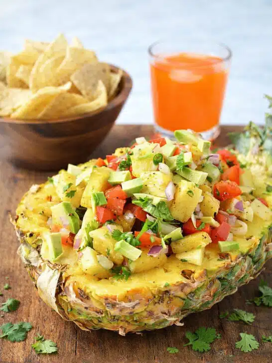 Pineapple salsa appetizer served with tortilla chips and fresh herbs