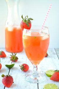 Refreshing summer strawberry lemonade poured over ice with fresh mint garnish
