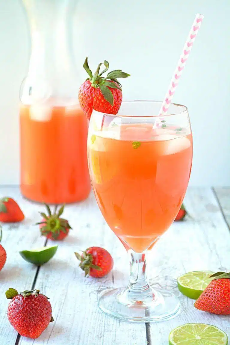 Refreshing summer strawberry lemonade poured over ice with fresh mint garnish