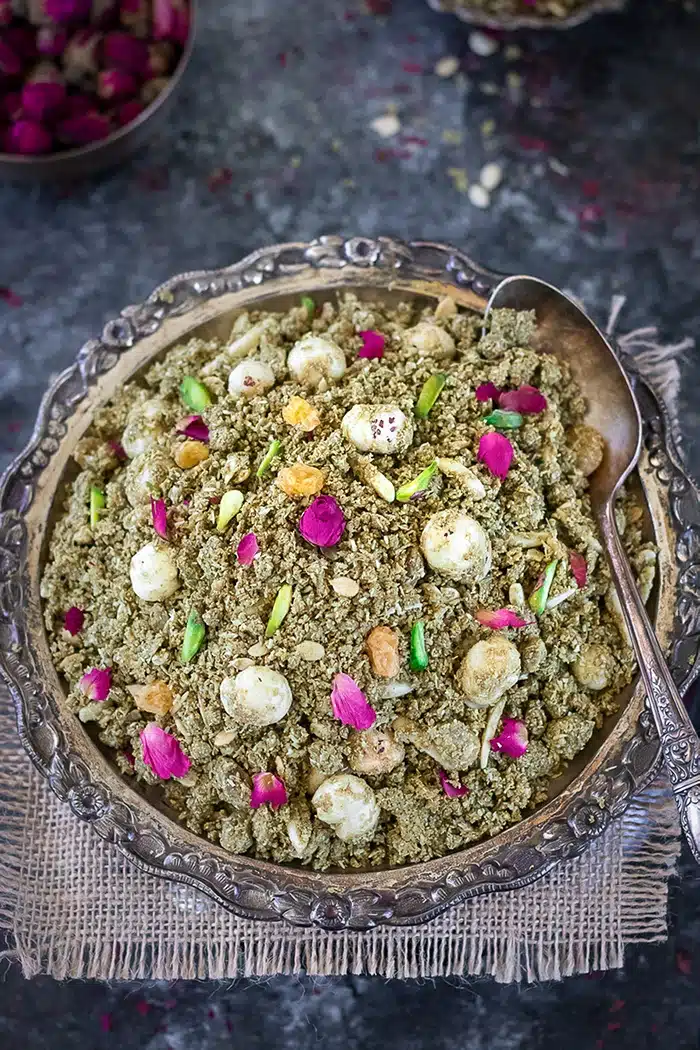 Janmashtami Dhaniya Panjiri  in a plate garnished with rose petals and pistachios