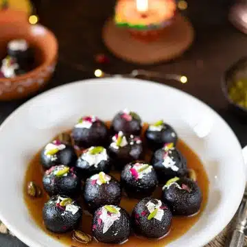 Kala Gulab Jamun in a plate garnished with edible silver foil