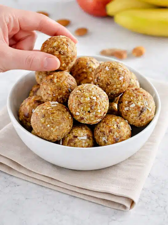 No bake healthy energy bites made with almonds dates coconut and raisins in a white bowl