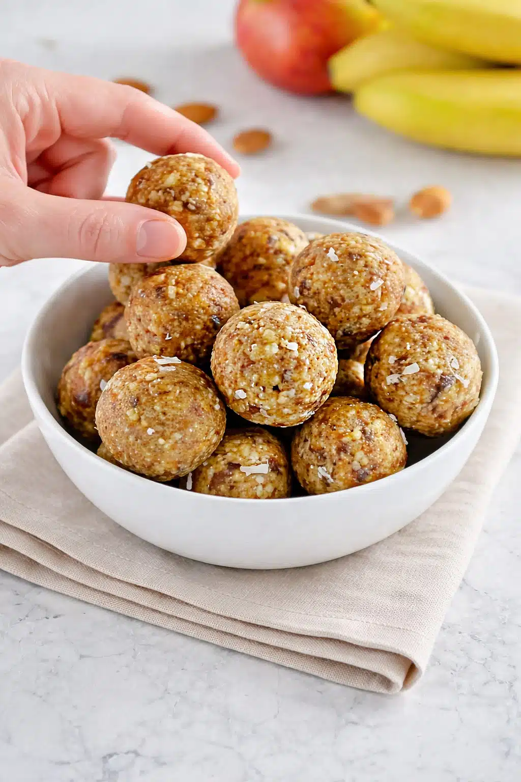 No bake healthy energy bites made with almonds dates coconut and raisins in a white bowl