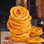 Freshly cooked Jalebi stacked on top and garnished with dried rose petals