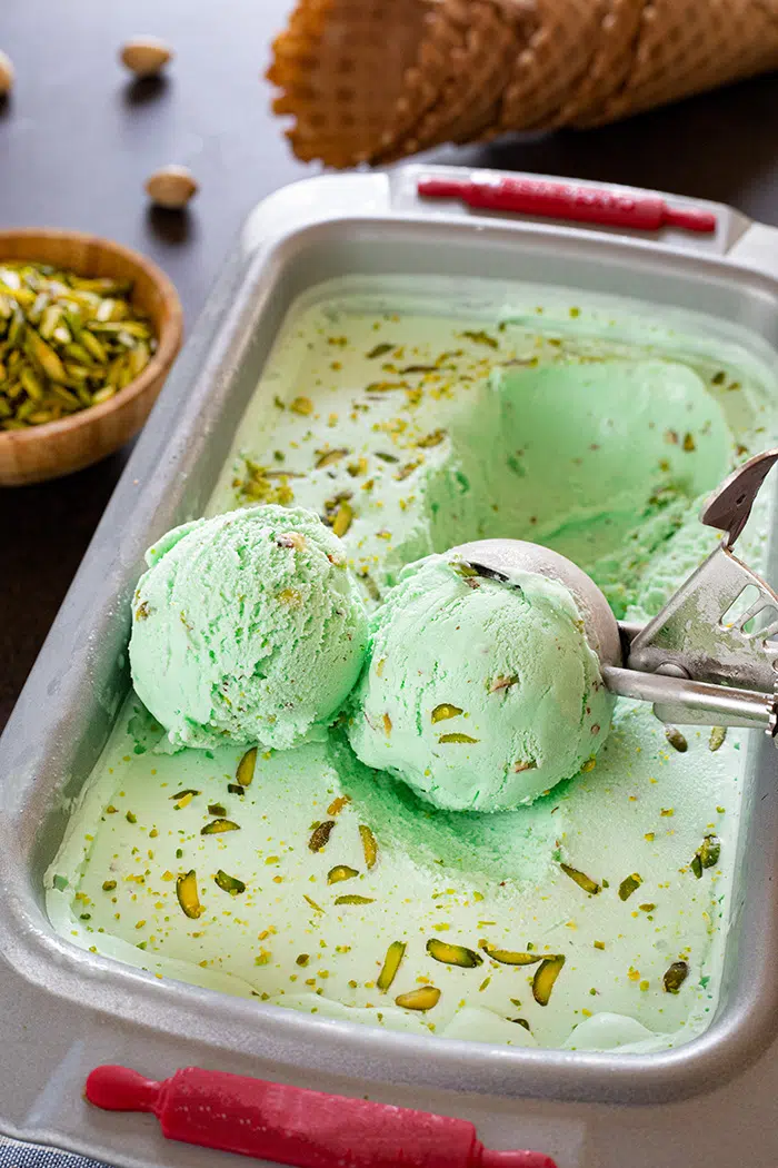 Scoops of no-churn homemade pistachio Ice cream in a tub