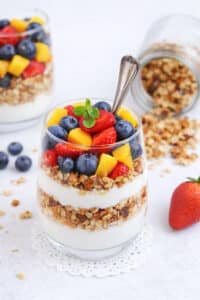Berry parfait layered with vanilla yogurt, fresh strawberries, blueberries, mango, and crunchy granola