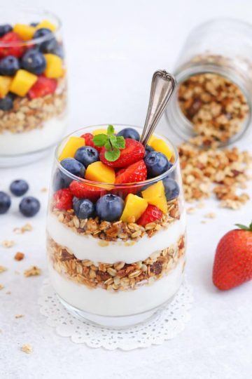 Berry parfait layered with vanilla yogurt, fresh strawberries, blueberries, mango, and crunchy granola