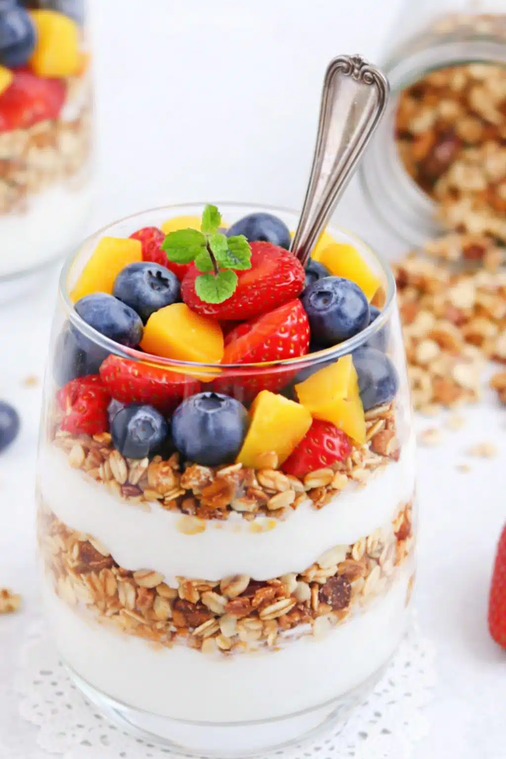 Easy breakfast made with yogurt, blueberries, strawberries, mango, and granola