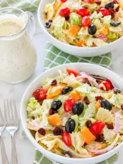 Cranberry Bowtie Pasta Salad in a bowl with dressing on the side