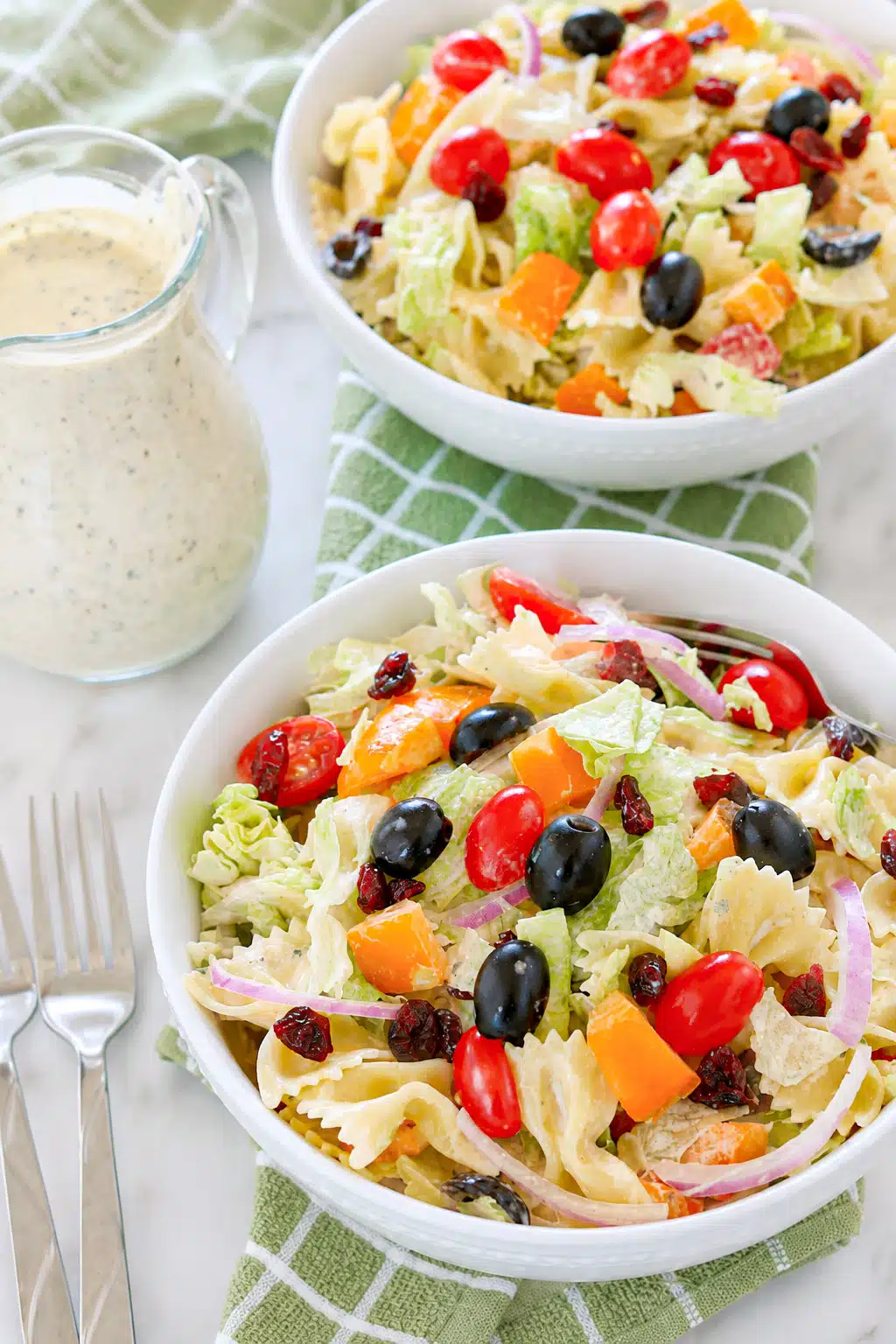 Cranberry Bowtie Pasta Salad in a bowl with dressing on the side