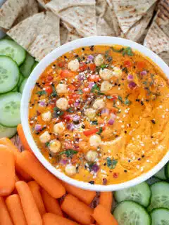 Roasted Red Bell Pepper And Chickpea Hummus garnished with herbs and onions
