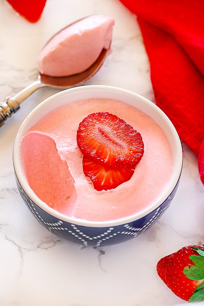 Eggless Strawberry mousse in a bowl with strawberries on top