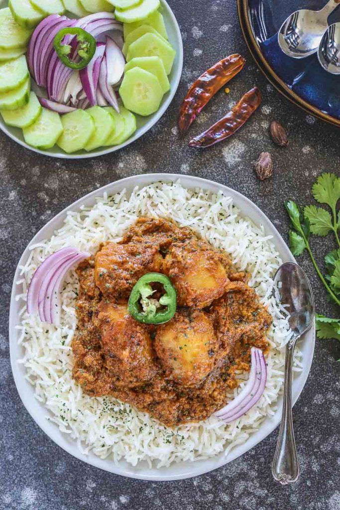 Instant Pot Dum Aloo over rice in a plate - Ruchiskitchen
