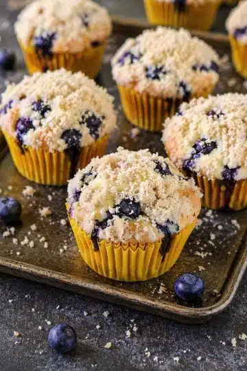 Cupcakes with crumb topping baked golden brown in a muffin tray.
