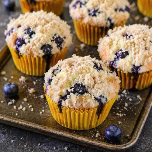 Cupcakes with crumb topping baked golden brown in a muffin tray.