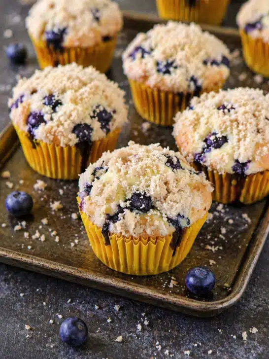 Cupcakes with crumb topping baked golden brown in a muffin tray.