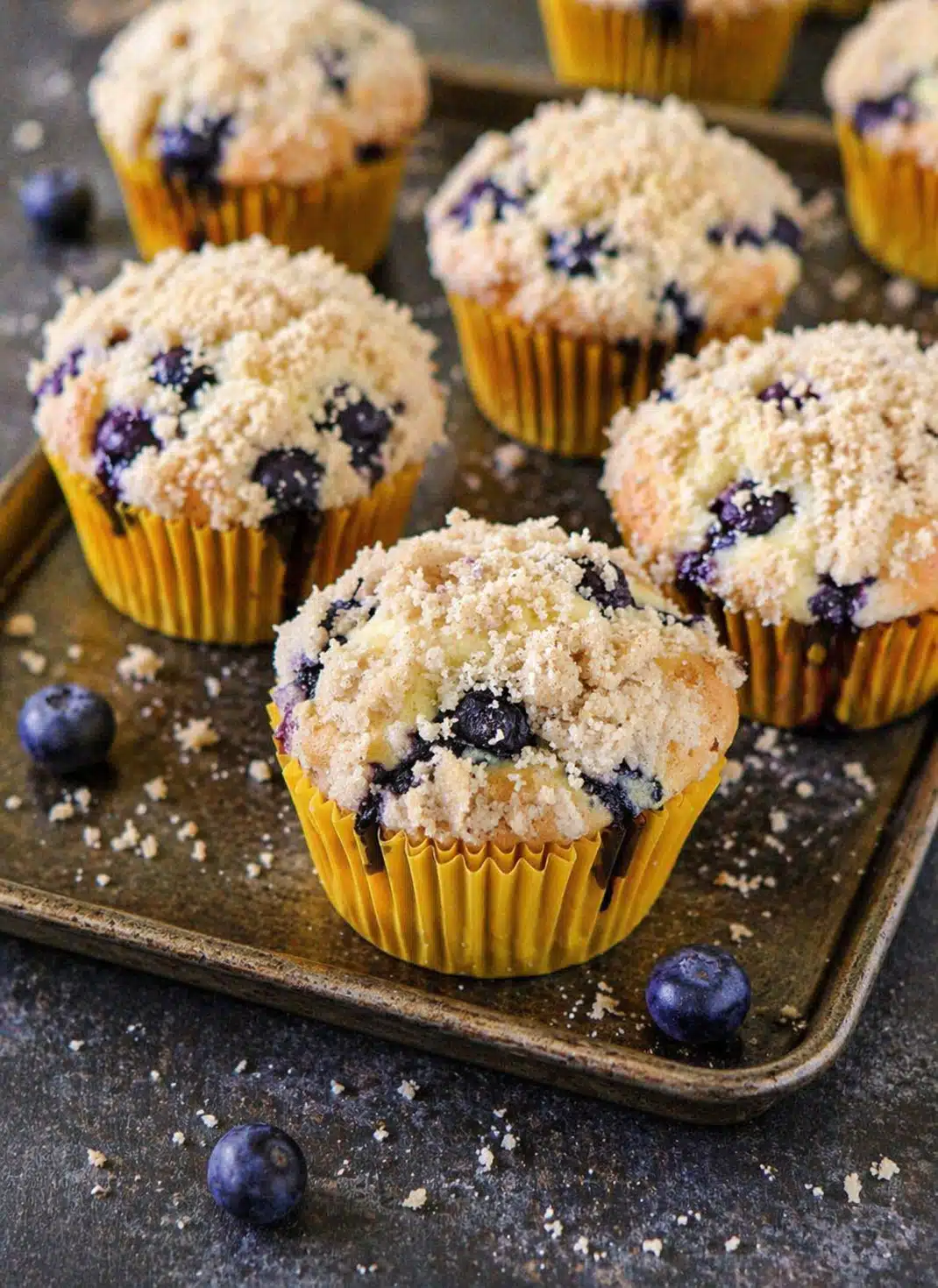 Cupcakes with crumb topping baked golden brown in a muffin tray.