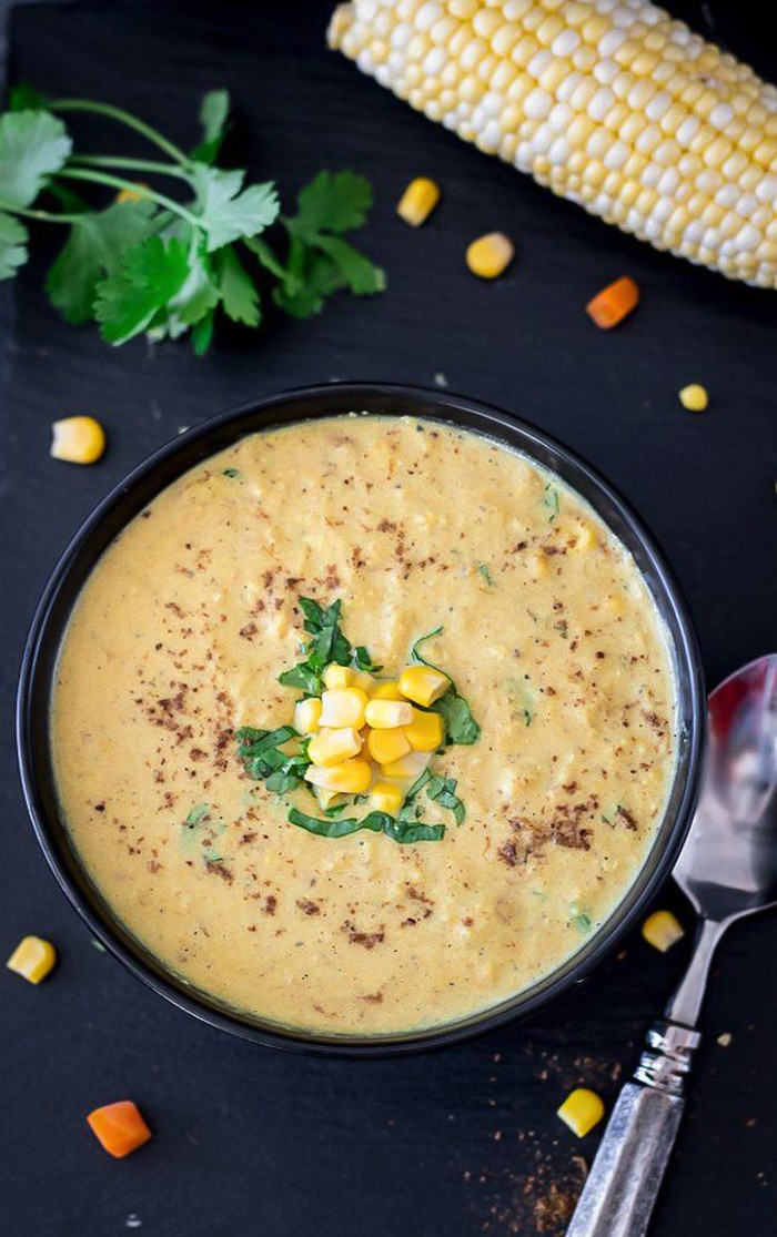 A warm Makai Ka Shorba (Spiced Corn Soup) garnished with corn kernels and cilantro leaves