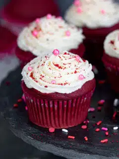 Eggless red velvet cupcakes garnished with sprinkles