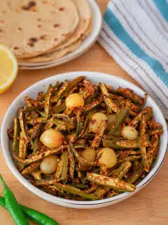 Bhindi Do pyaza served in a white bowl with rotis