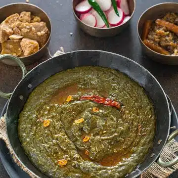 Sarson ka saag in a kadhai garnished with garlic tempering