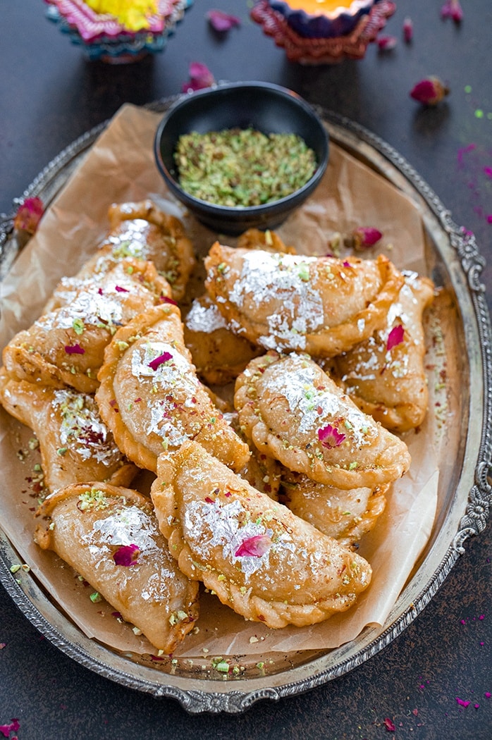 Gujiya on a tray with pistachios