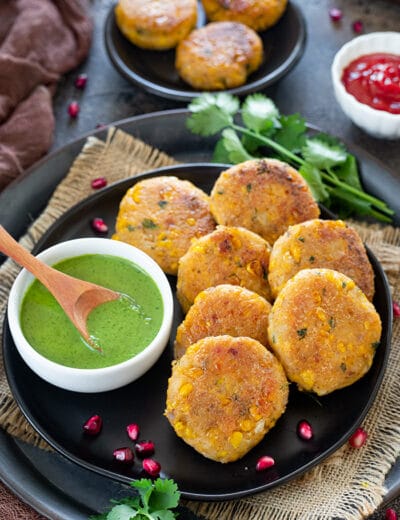 Corn kebabas on a tray with green chutney