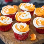 Eggless Orange Cupcakes frosted on a wooden tray