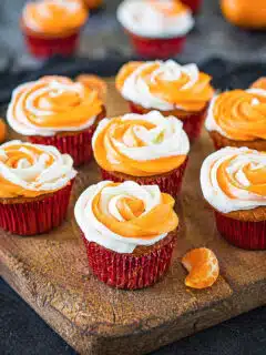 Eggless Orange Cupcakes frosted on a wooden tray