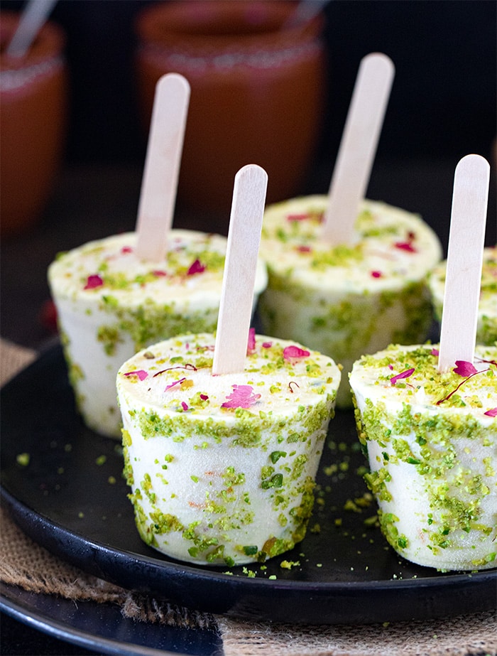 Kesar Pista Kulfi on a plate with khullad in background