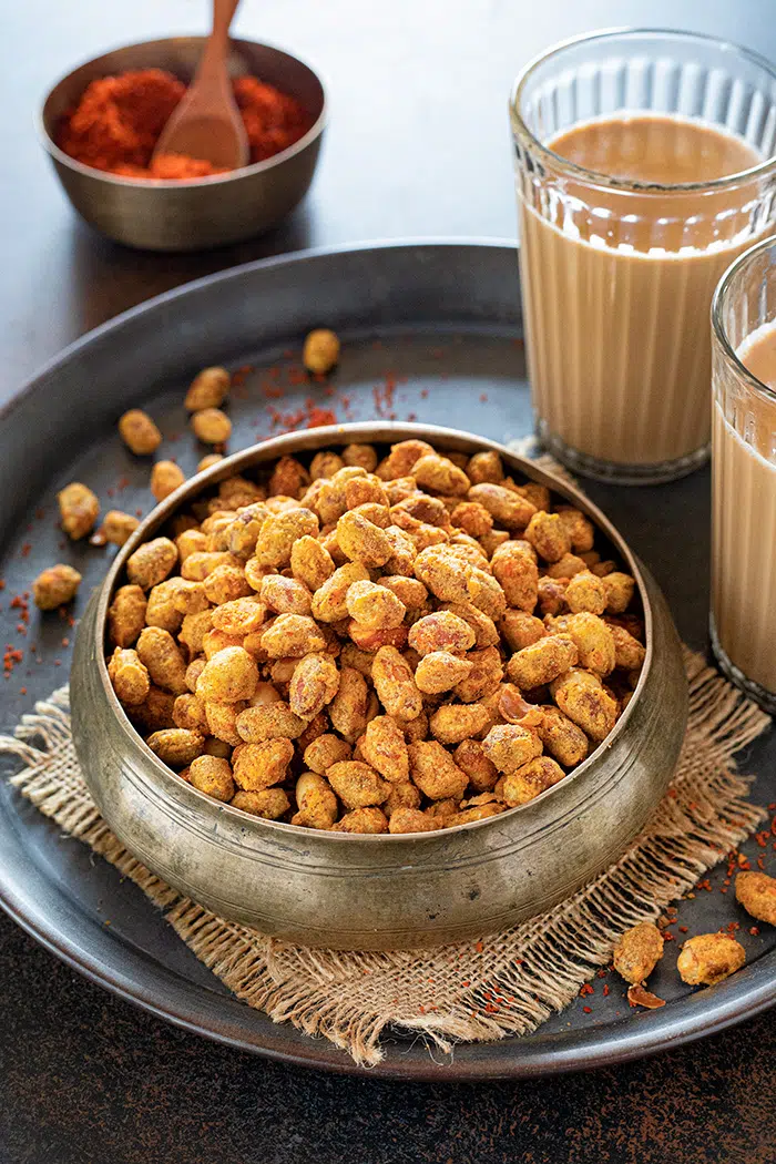 Achari Masala Peanuts with tea in a bowl