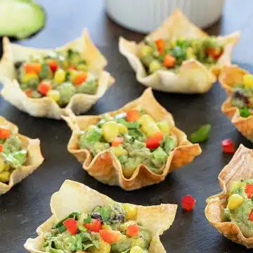 Avocado and corn wonton bites on a black tray