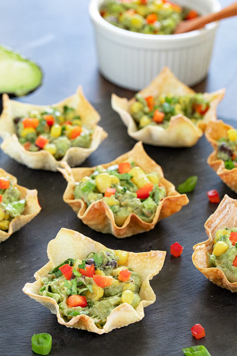 Avocado and corn wonton bites on a black tray