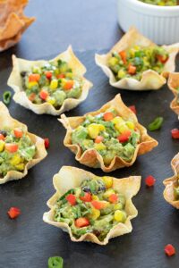 Avocado Wonton bites garnished with cilantro and bell pepper